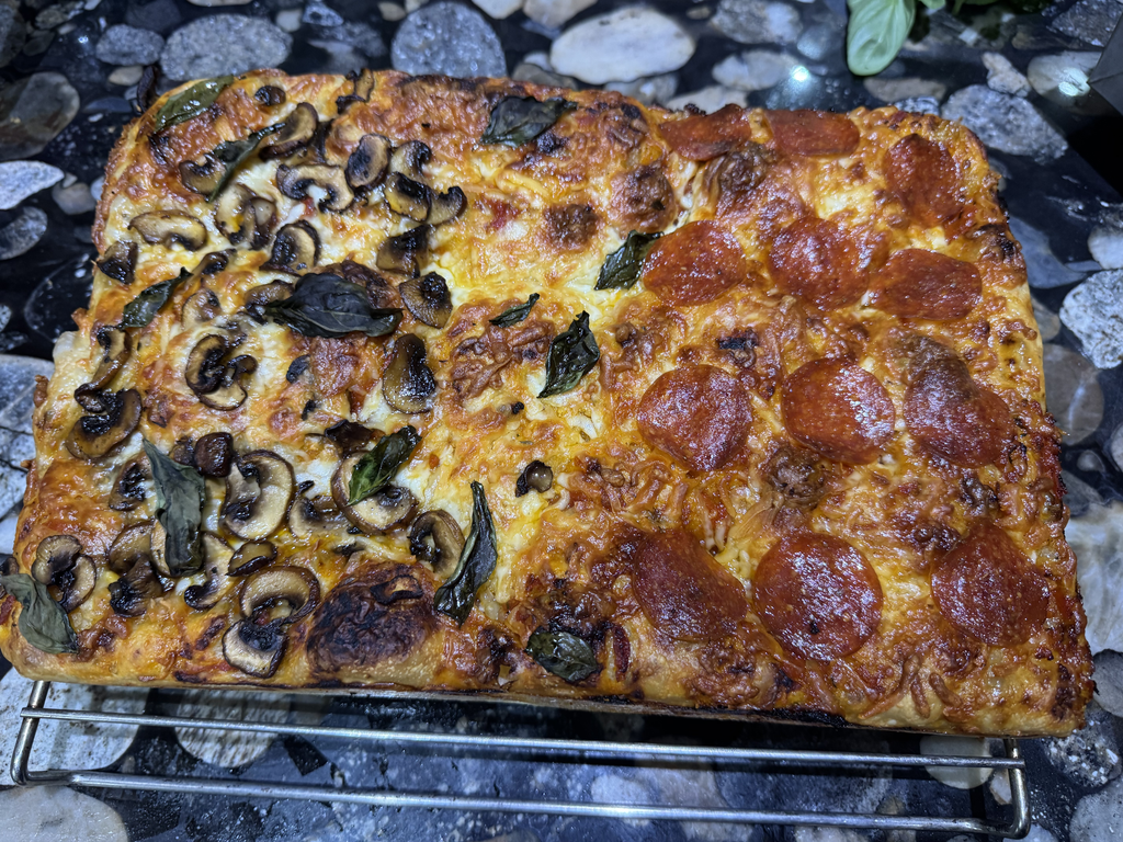 Focaccia pizza cooling on a rack after leaving the pan