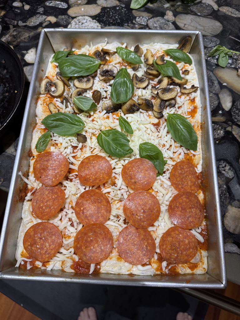 Cheese and pizza fixings arranged over focaccia pizza